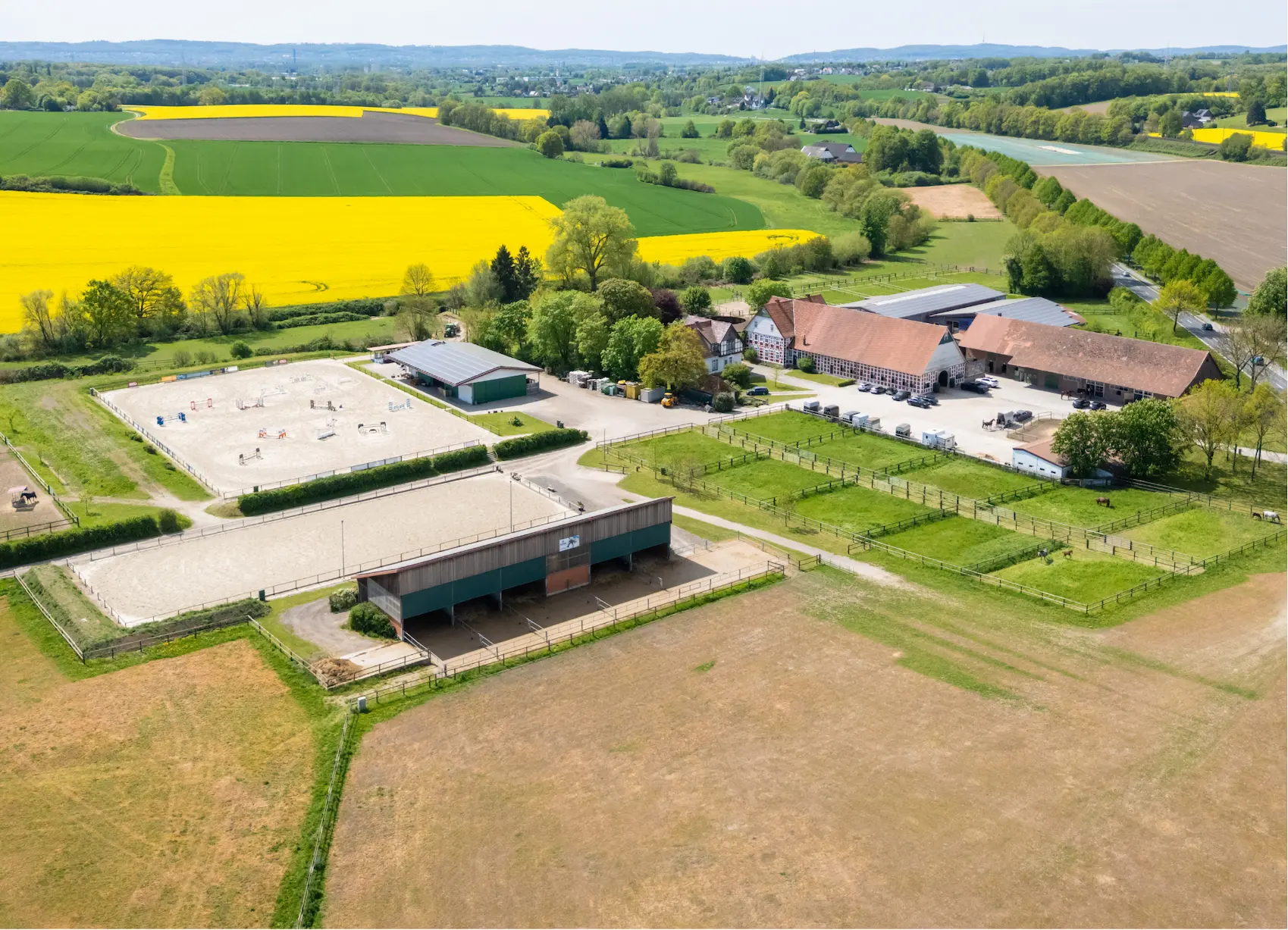 Luftaufnahme des Hofs Meyer zu Hartum mit Hallen, Plätzen und Weiden